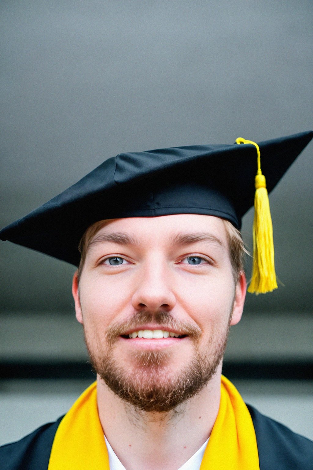 happy  man in Graduation Ceremony wearing a square black Graduation Cap with yellow tassel at college