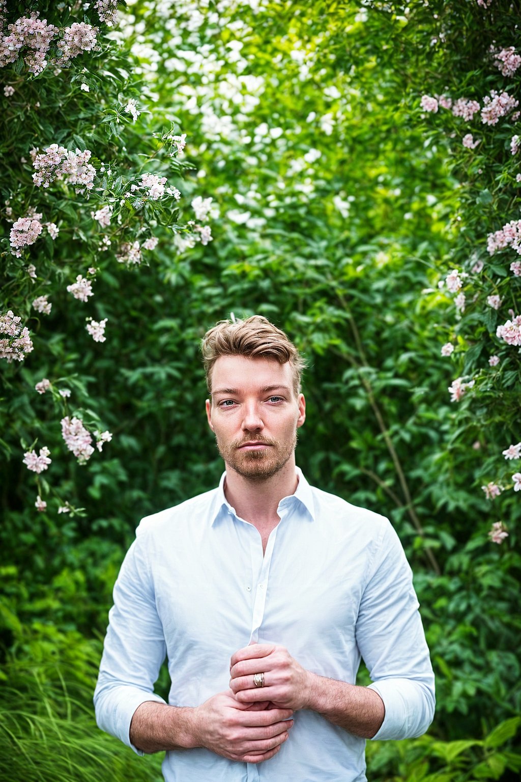 a captivating masculine  man embracing nature, surrounded by lush greenery or blooming flowers in a garden