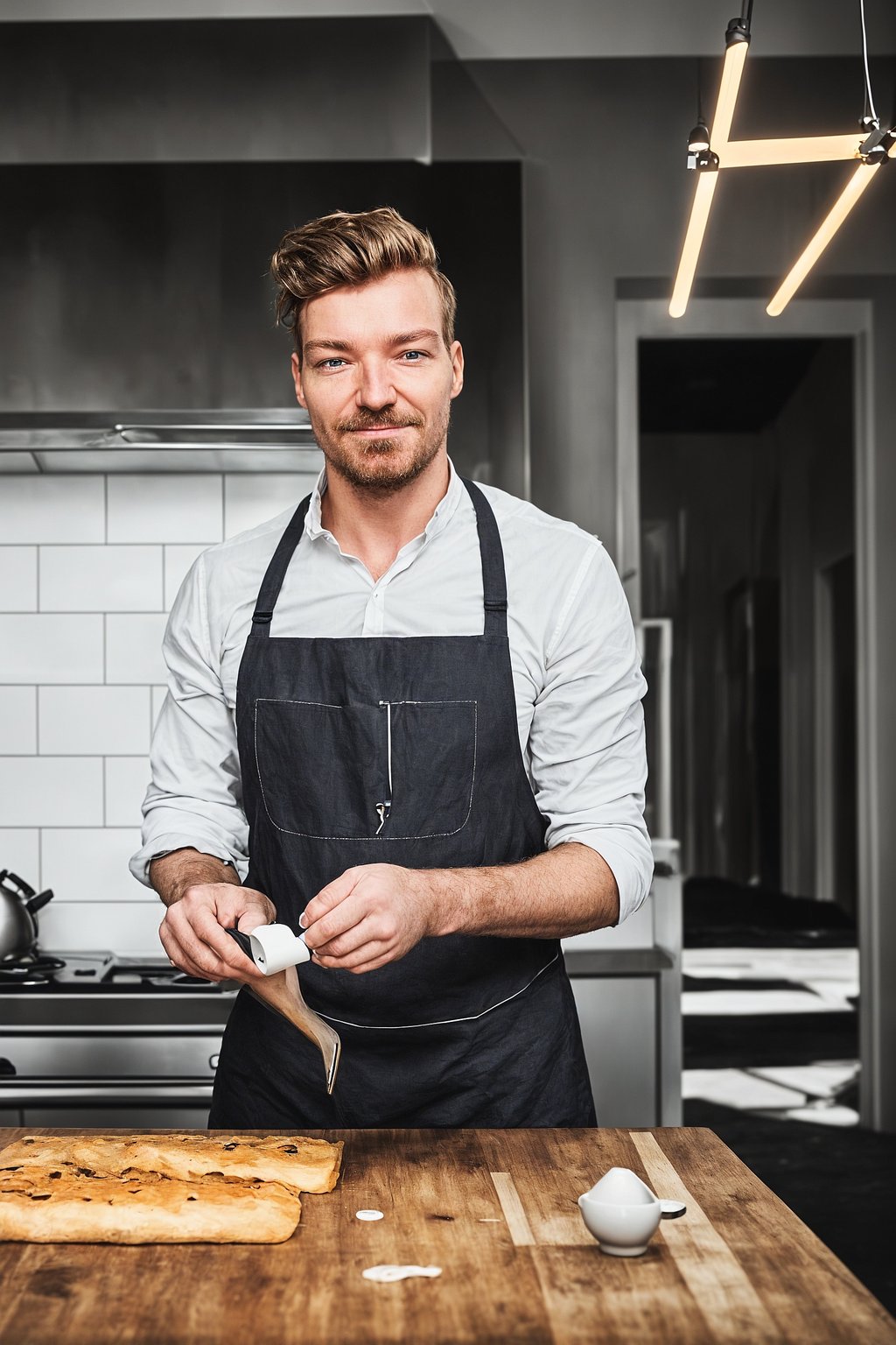 smiling masculine  man cooking or baking in a modern kitchen