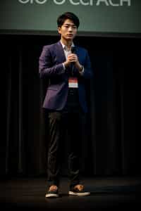 man as a conference keynote speaker standing on stage at a conference