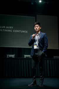man as a conference keynote speaker standing on stage at a conference