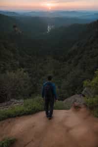 man on a hiking trail, overlooking a breathtaking mountain landscape