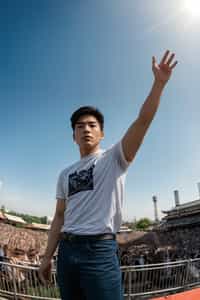 a man enjoying the live music on a sunny day, surrounded by  energetic fans and raising their hands in excitement