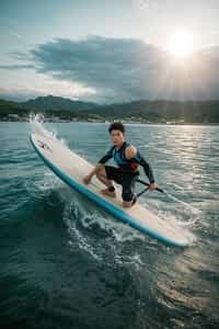a charming masculine  man showcasing their adventurous side while participating in water sports like surfing or paddleboarding