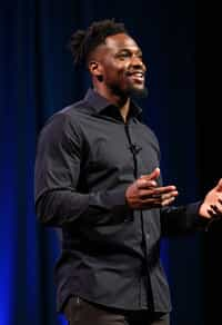 man as a conference keynote speaker standing on stage at a conference