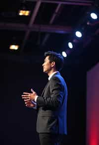 man as a conference keynote speaker standing on stage at a conference