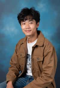 (school portrait) photo headshot of a young 18 y o man in 1990s style, nineties style, 90s, 1990s fashion, 1990s hair, school, man is sitting and posing for a (yearbook) picture, blue yearbook background, official school yearbook photo, man sitting (looking straight into camera), (school shoot), (inside), blue yearbook background