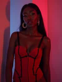 woman wearing (red bodycon dress) with (black suspenders garter straps)  in night club neon lights