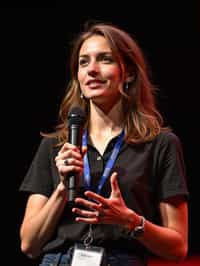 TedX speaker woman holding microphone with lanyard around his neck