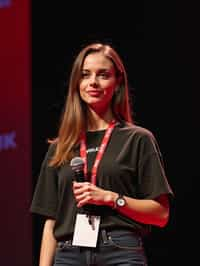 TedX speaker woman holding microphone with lanyard around his neck