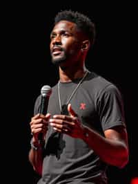 TedX speaker man holding microphone with lanyard around his neck