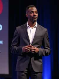 man as a conference keynote speaker standing on stage at a conference