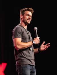 TedX speaker man holding microphone with lanyard around his neck