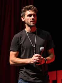 TedX speaker man holding microphone with lanyard around his neck