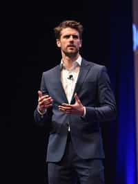 man as a conference keynote speaker standing on stage at a conference