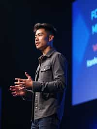 man as a conference keynote speaker standing on stage at a conference