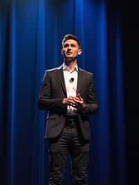 man as a conference keynote speaker standing on stage at a conference