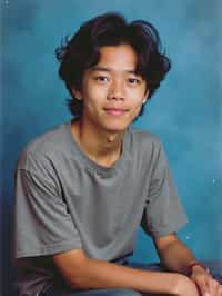 (school portrait) photo headshot of a young 18 y o man in 1990s style, nineties style, 90s, 1990s fashion, 1990s hair, school, man is sitting and posing for a (yearbook) picture, blue yearbook background, official school yearbook photo, man sitting (looking straight into camera), (school shoot), (inside), blue yearbook background